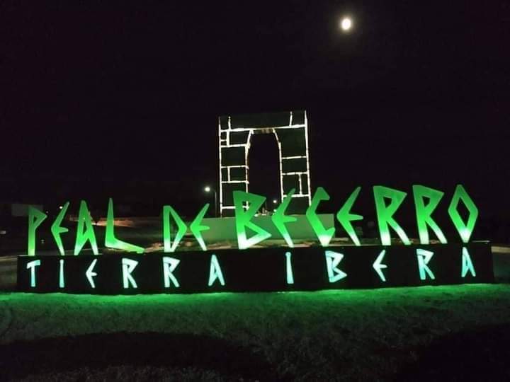 A big sign of the city of Peal de Becerro, is illuminated in 						green.