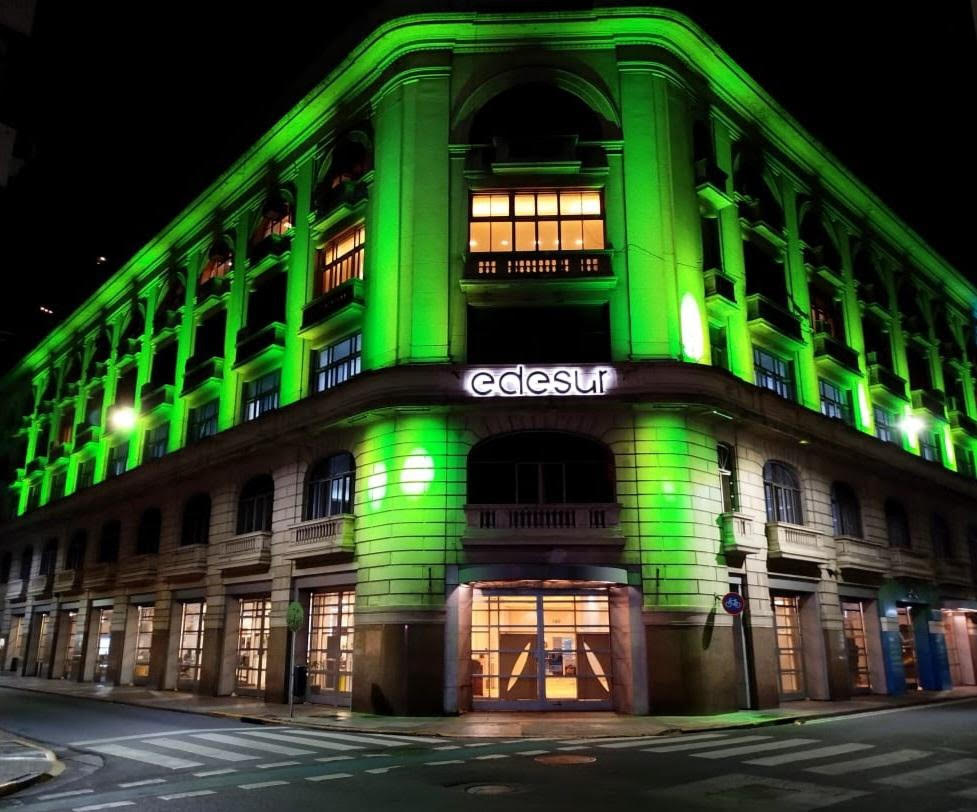 A facade of an elegant-looking building in Buenos Aires lit mito green