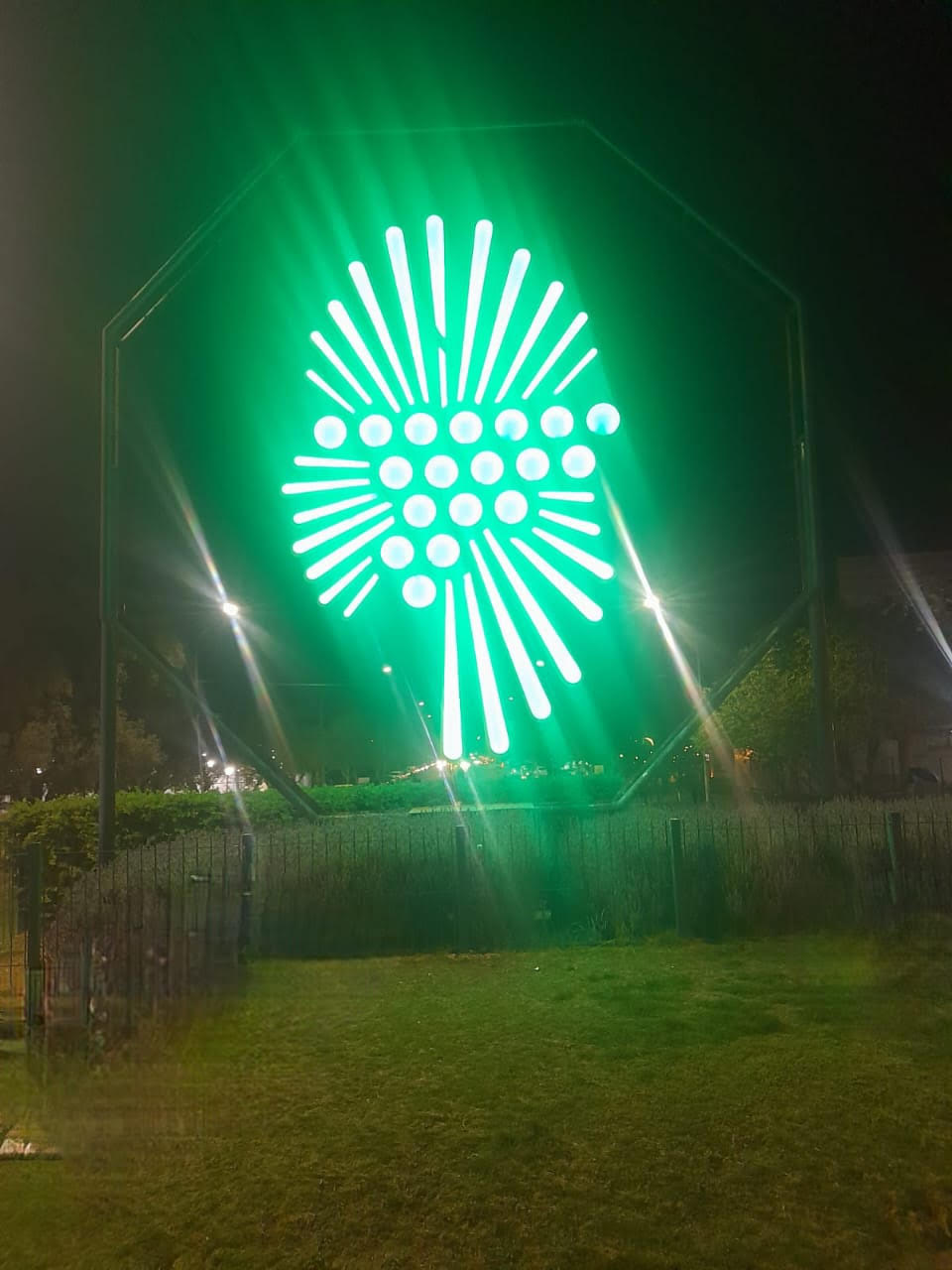 An art instalation consisting of circles and elongated element illuminated mito green