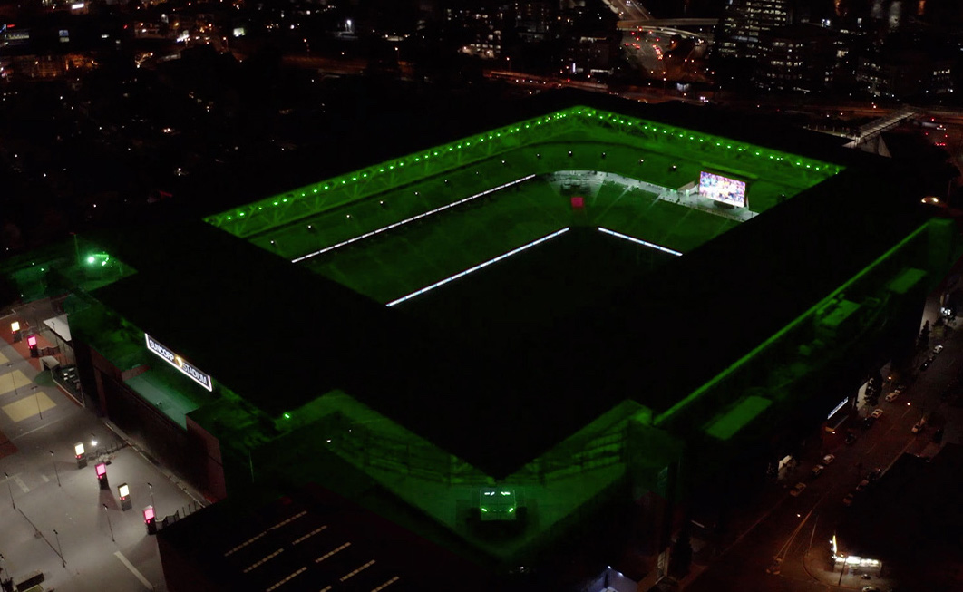 An enormous rugby and football stadium lit mito green